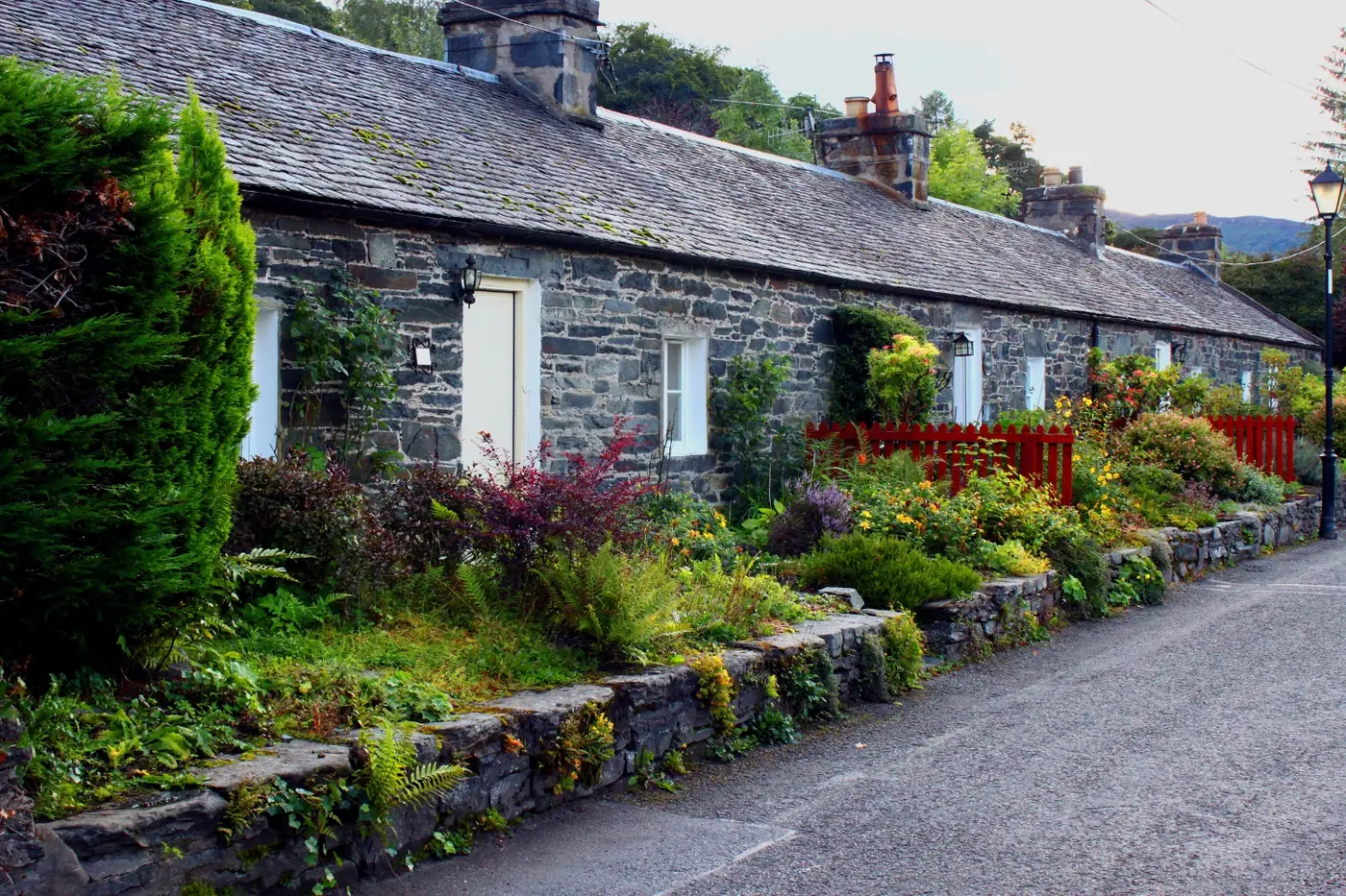 Beautiful Scottish village of Glencoe nestled in Highland valley with dramatic mountains - one of Scotland's best villages to visit